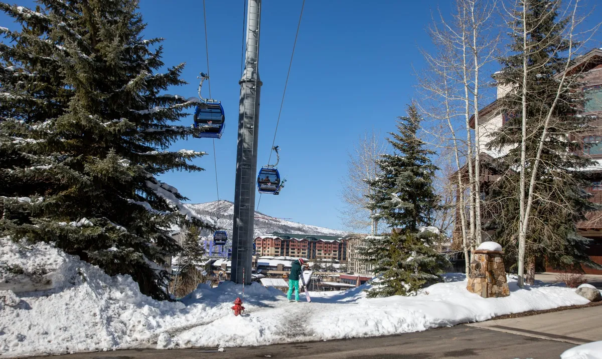 A cheerful scene with people skiing and walking near a ski lift, surrounded by snowy ground and towering trees. The lively atmosphere highlights both active fun and gathering spots, with a focus on the thrill of winter sports and communal excitement.